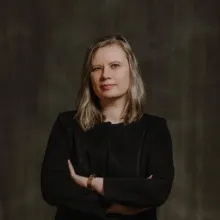 Blonde woman with arms crossed.