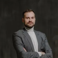 A man stands with arms crossed.