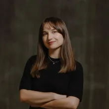 Brunette woman with arms crossed.